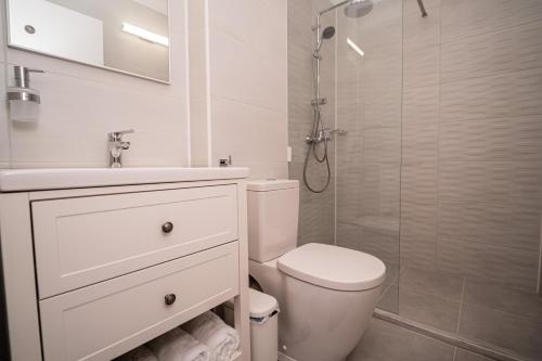ein weißes Badezimmer mit Toilette und Dusche in der Unterkunft Studio SARA in Saturn