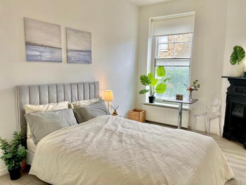 a bedroom with a bed and two windows at Archway Station Big Bedroom Flat in London