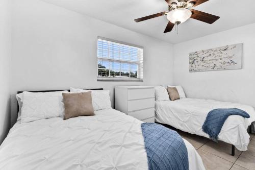 - une chambre avec 2 lits et un ventilateur de plafond dans l'établissement Peaceful 3 Bedroom House with Relaxing Backyard 15 minutes to the Ocean, à Hollywood