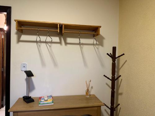 a room with a desk and a shelf on a wall at Apê Central Bonito in Bonito