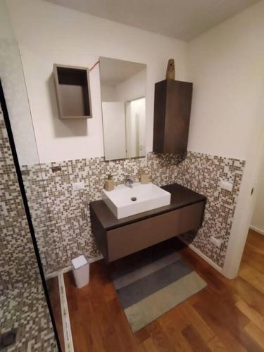 a bathroom with a sink and a mirror at In viaggio con Pippo - Ampio appartamento con AC nei pressi di Piazza Bovio e del Rivellino in Piombino