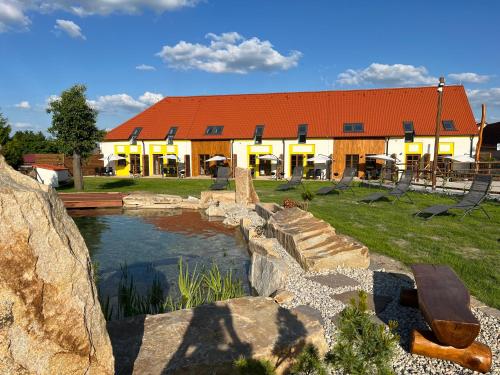a building with a pond in front of a building at Wellness zoo apartmány Lhota in Lomnice nad Lužnicí
