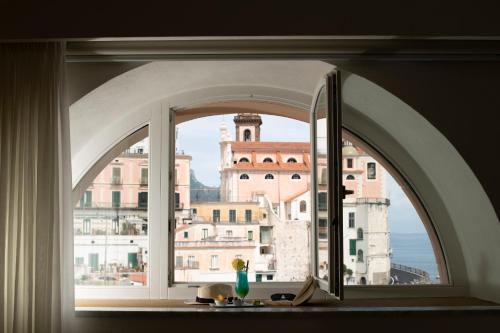 an arch window with a view of a city at Palazzo Ferraioli - Hotel & Wellness in Atrani