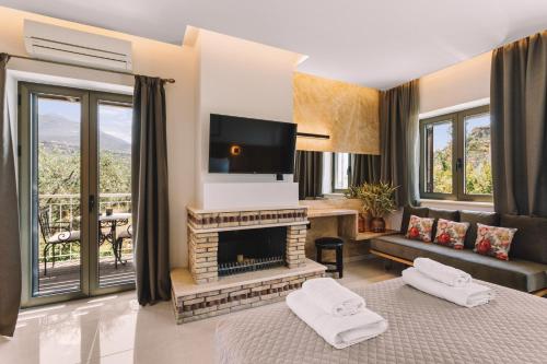 a living room with a fireplace and a tv at Bonos apartments in Stoupa