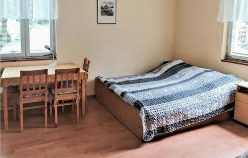a bedroom with a bed and a table and chairs at 1 Bedroom Gorgeous Home In Gardna Wielka in Gardna Wielka