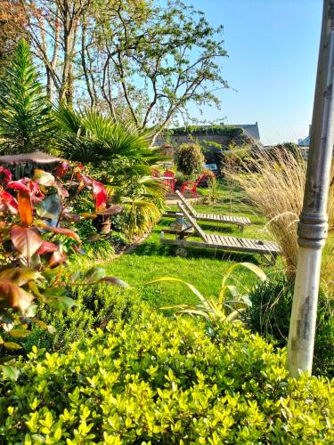 a garden with flowers and a pole in the grass at Le Jardin Secret & Spa - Chambre d'Hôtes in Saint-Brieuc
