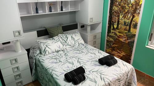 1 dormitorio con 1 cama con 2 almohadas negras en Casa gorgona, en León