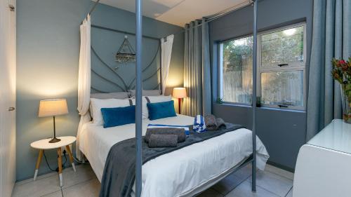 a bedroom with a bed with blue walls at Noordhoek Bliss Beach House in Cape Town