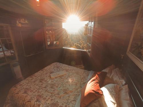 a room with a bed and a light in it at Mansão Austríaca Guesthouse in Campos do Jordão