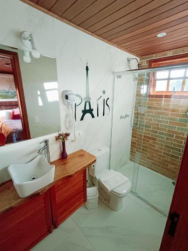 a bathroom with a toilet and a sink and a shower at Mansão Austríaca Guesthouse in Campos do Jordão