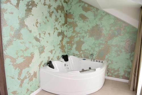 La salle de bains est pourvue d'un lavabo blanc et d'un mur vert. dans l'établissement Hotel Royal, à Shkodër