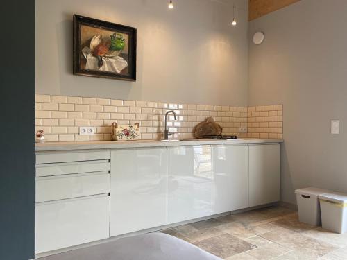 une cuisine avec des armoires blanches et un évier dans l'établissement Le Bos Dordogne, à Soulaures