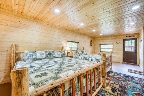 a bedroom with two beds in a log cabin at Charming Cabin Near Roaring River State Park! in Cassville