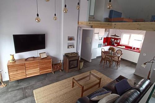 a living room with a couch and a tv and a kitchen at Casa Pieiteiro in Corcubión