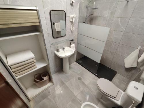 a bathroom with a white toilet and a sink at Sol Nascente Apartment in Albufeira