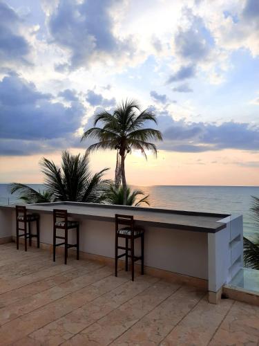 a bar on the beach with a view of the ocean at Hotel Rilux Tolu in Tolú