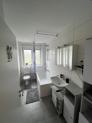 een witte badkamer met een bad en een wastafel bij Aspava Apartments in Günzburg