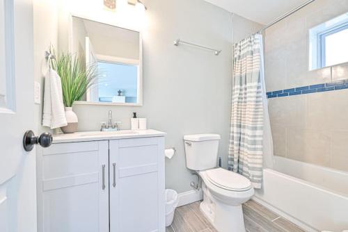 uma casa de banho branca com um WC e um lavatório em 318 E Youngs Ave Unit 1 Seaside Serenity Salty Shore Retreat em Wildwood