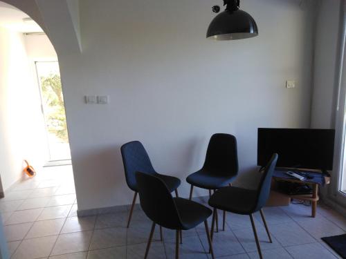 Habitación con 4 sillas, mesa y TV. en Lux apartman, en Žuljana