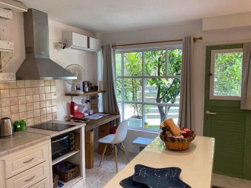 a kitchen with a green door and a window at jasmine apartments in Eretria