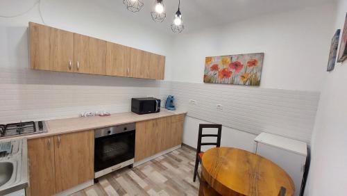 a small kitchen with a table and a microwave at Apartament Diaconu Coresi (Piata Sfatului) in Braşov