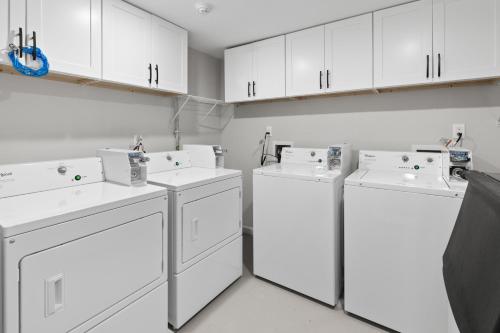 a laundry room with three whitewashes and white cabinets at The Beach House in Wildwood