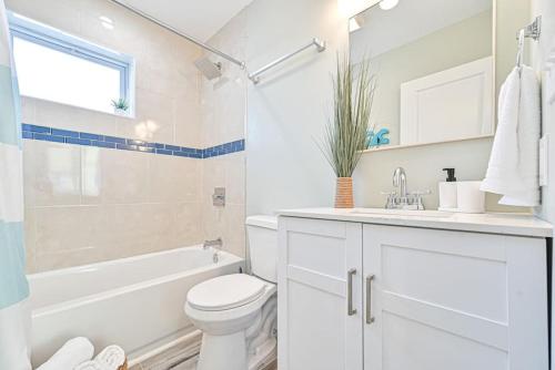 a white bathroom with a toilet and a tub and a sink at 318 E Youngs Ave Unit 3 Serene Seaside Retreat Salty Shore in Wildwood