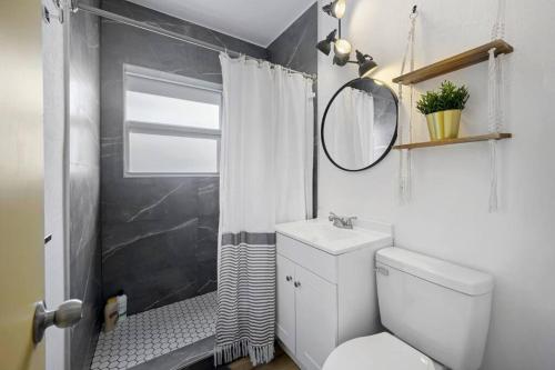 La salle de bains est pourvue de toilettes et d'une douche avec un miroir. dans l'établissement New stylish open space: fast Wii-fi and parking, à Fort Lauderdale