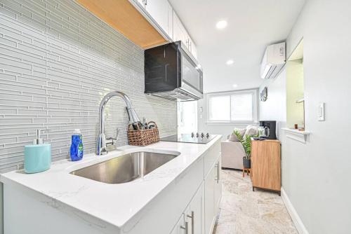 a white kitchen with a sink and a refrigerator at 318 E Youngs Ave Unit 4 Charming Salty Shore Retreat Your Perfect Getaway in Wildwood
