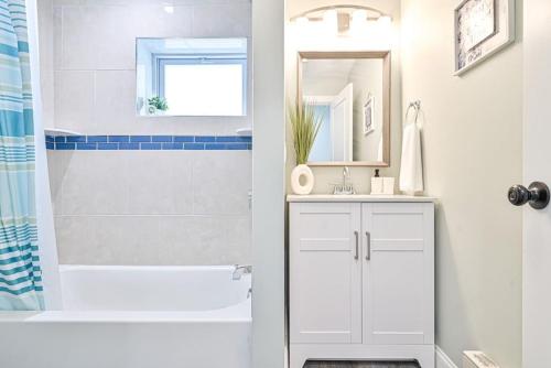 a bathroom with a white tub and a sink and a mirror at 318 E Youngs Ave Unit 5 Salty Shore Oasis Spectacular Retreat in Wildwood