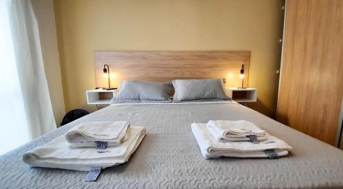1 dormitorio con 1 cama con toallas en Servando Deptos Turísticos en San Rafael
