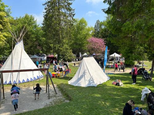 a group of people in a park with tents at La Petite Maison in Pont-d'Ouilly