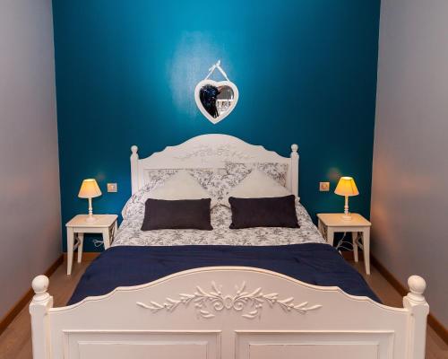 een slaapkamer met een wit bed en een blauwe muur bij Charleville-Mézières: belle vue Place Ducale in Charleville-Mézières