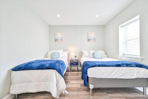 een slaapkamer met 2 bedden en een raam bij 318 E Youngs Ave Unit 7 Salty Shore Retreat Coastal Charm Tranquility in Wildwood