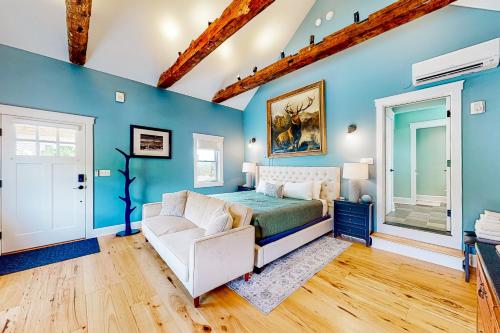 a bedroom with blue walls and a bed and a couch at The Lodge - Suite #3 in Waterbury