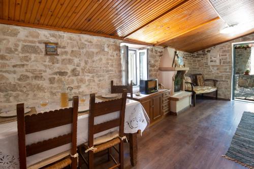 a bedroom with a bed and a stone wall at Ionian Stone Home with Terrace in Bogdanátika