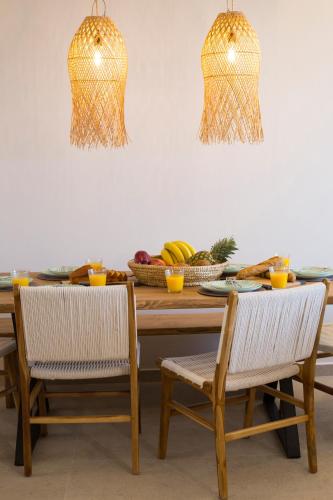 a dining room table with two chairs and a bowl of fruit at Muses of art Villas in Afantou