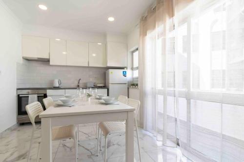 アルマカオ・デ・ペラにあるModern Apartment Beach Viewの白いテーブルと椅子のある白いキッチン
