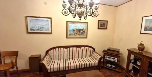 a living room with a couch and a chandelier at La Corte sul Conero Casa Vacanze in Camerano