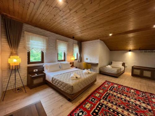 1 dormitorio con cama, sofá y alfombra en The Stone Sky Hotel en Gjirokastër