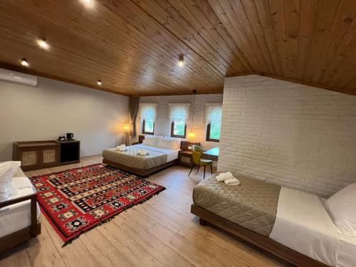 a large bedroom with two beds and a living room at The Stone Sky Hotel in Gjirokastër