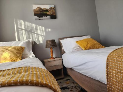 a bedroom with two beds and a lamp on a night stand at Motebong Villa in Maseru