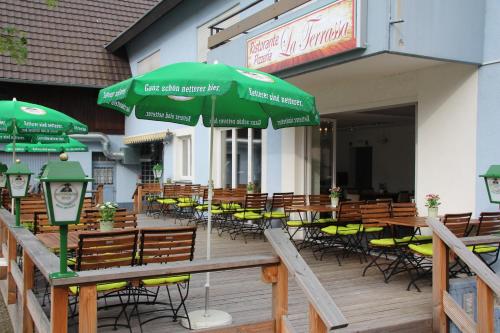 an outdoor patio with chairs and tables and umbrellas at Pension Mimosa in Rust