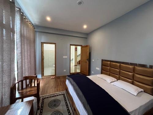 a bedroom with a large bed and a large window at Honey Bee in Leh