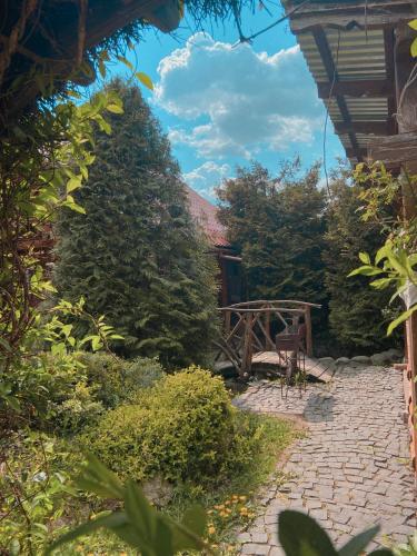 a garden with a brick walkway and a wooden bench at Вілла де Кампо in Chynadiyovo