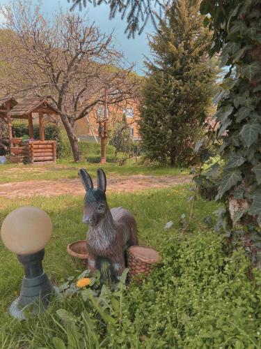 a statue of a rabbit sitting in the grass at Вілла де Кампо in Chynadiyovo