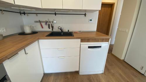 a kitchen with white cabinets and a sink at Japandi apartamentai in Kaunas