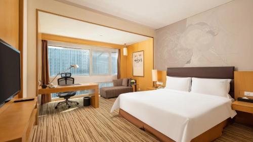a hotel room with a bed and a desk and a television at Holiday Inn Shijiazhuang Central by IHG in Shijiazhuang