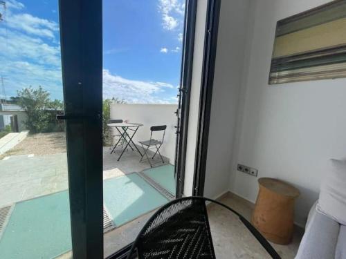 Zimmer mit Glastür und Blick auf den Innenhof in der Unterkunft LUXURY House with Stunning Sea Views - Ses Salines in La Savina