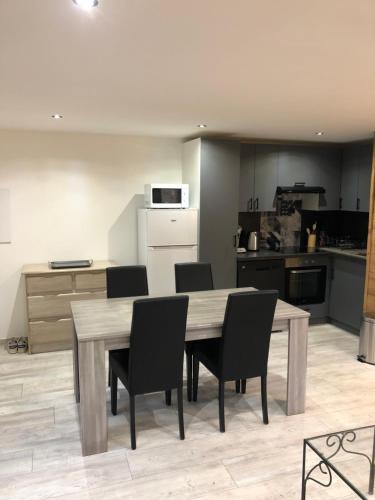 une cuisine avec une table et des chaises en bois dans l'établissement Chez marius, à La Cabanasse